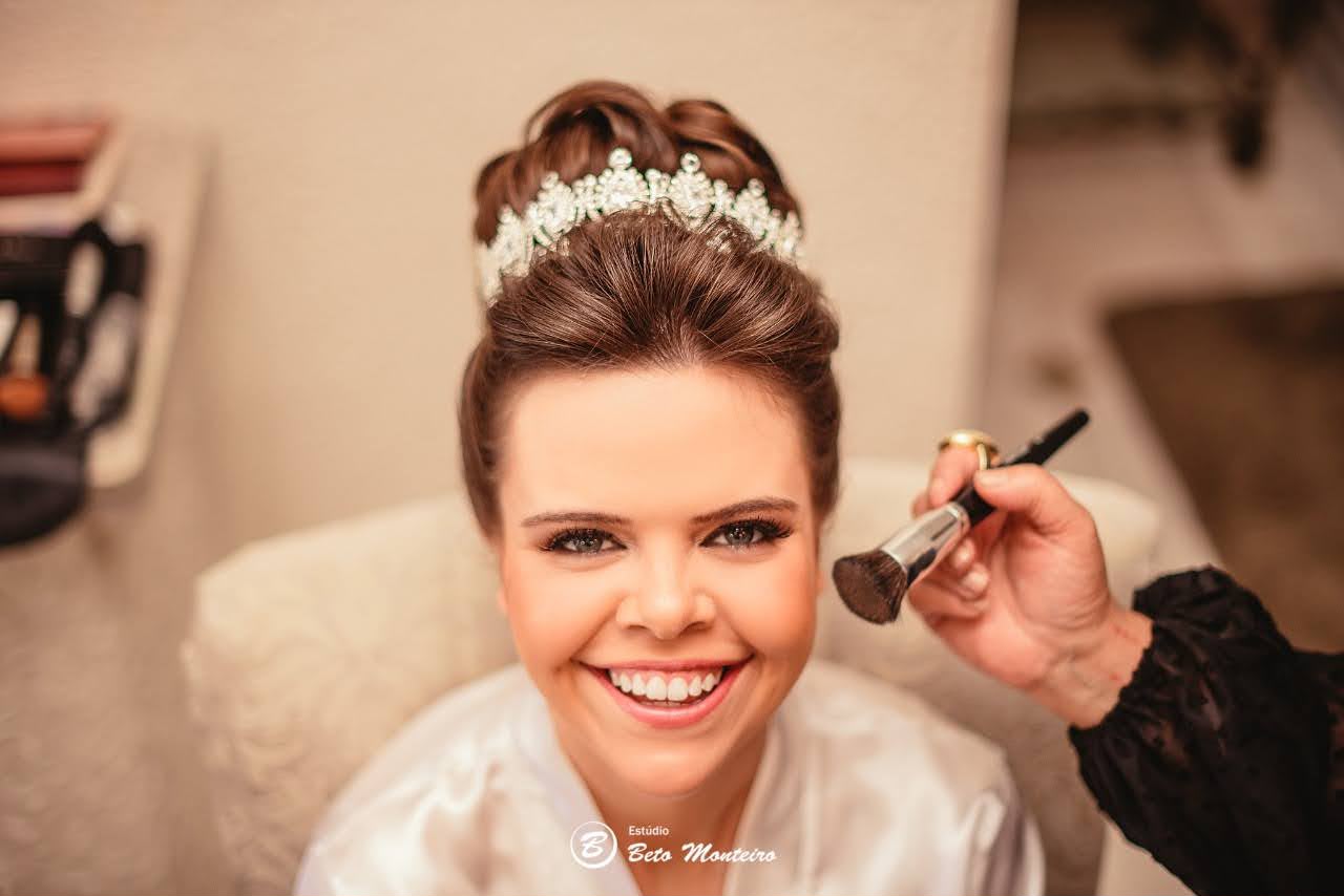 Noiva com tiara recebendo maquiagem